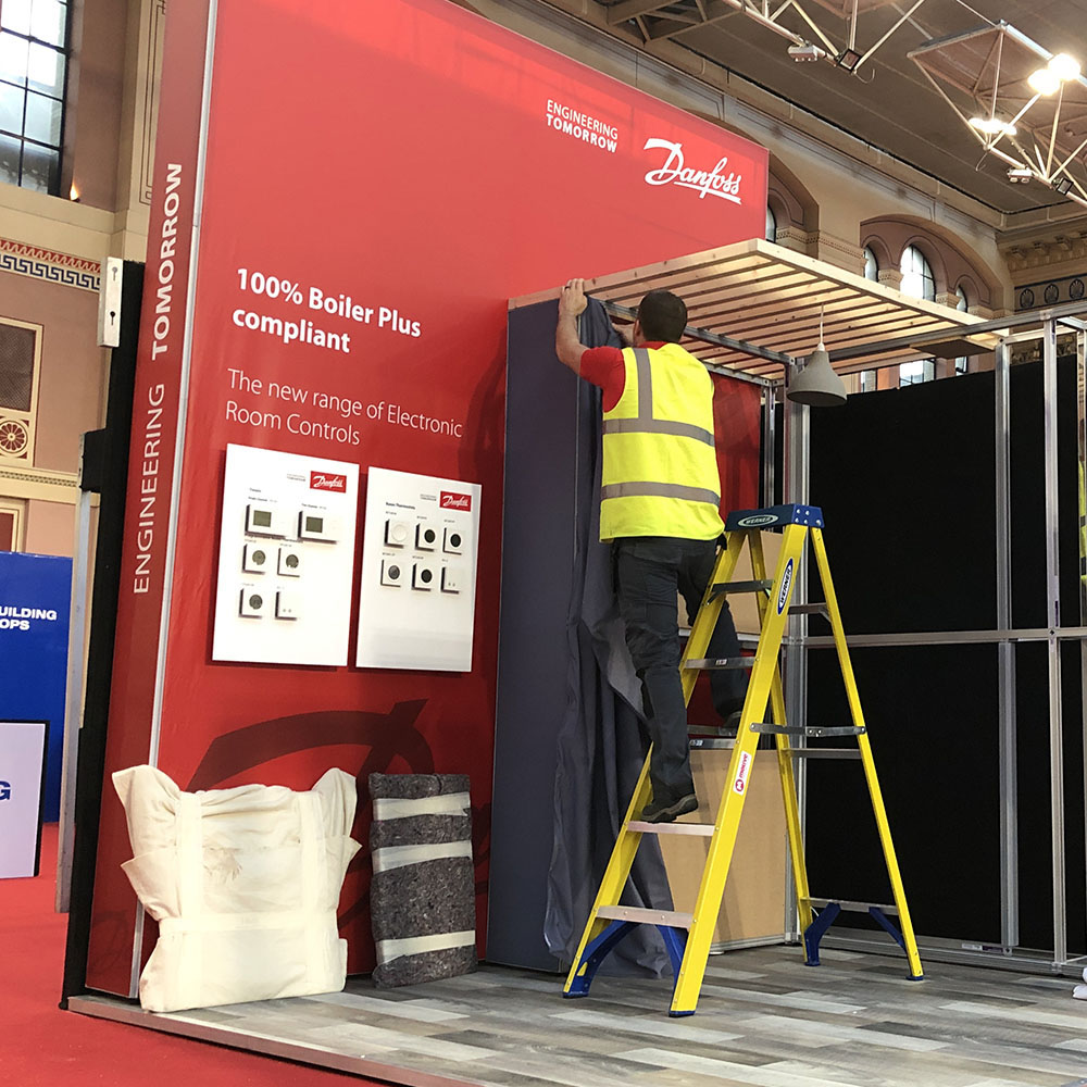 Exhibition Fitter on Ladder | Exhibition stand Hire | Motive Graphics